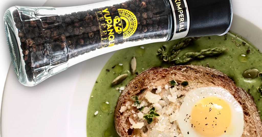 Yupanqui Black Imperial black peppercorn grinder beside egg and avocado toast